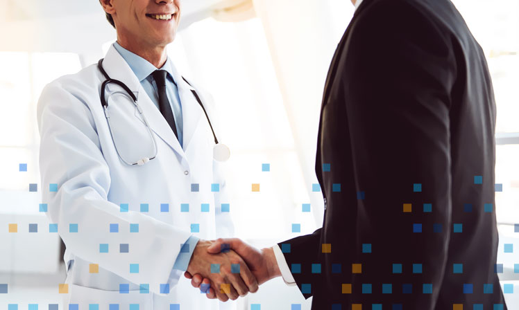 Médico y especialista en desarrollo de software saludándose con la mano