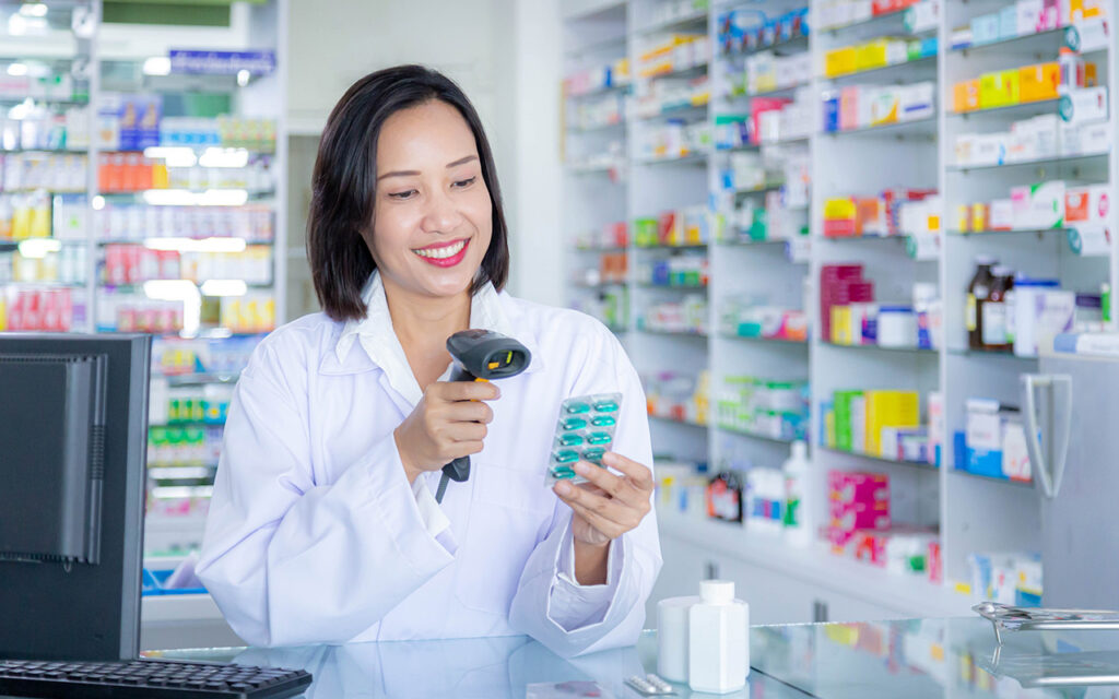 Mujer químico farmacéutico escaneando blíster de pastillas en farmacia - Post farmacias automatizadas - Blog LOLIMSA